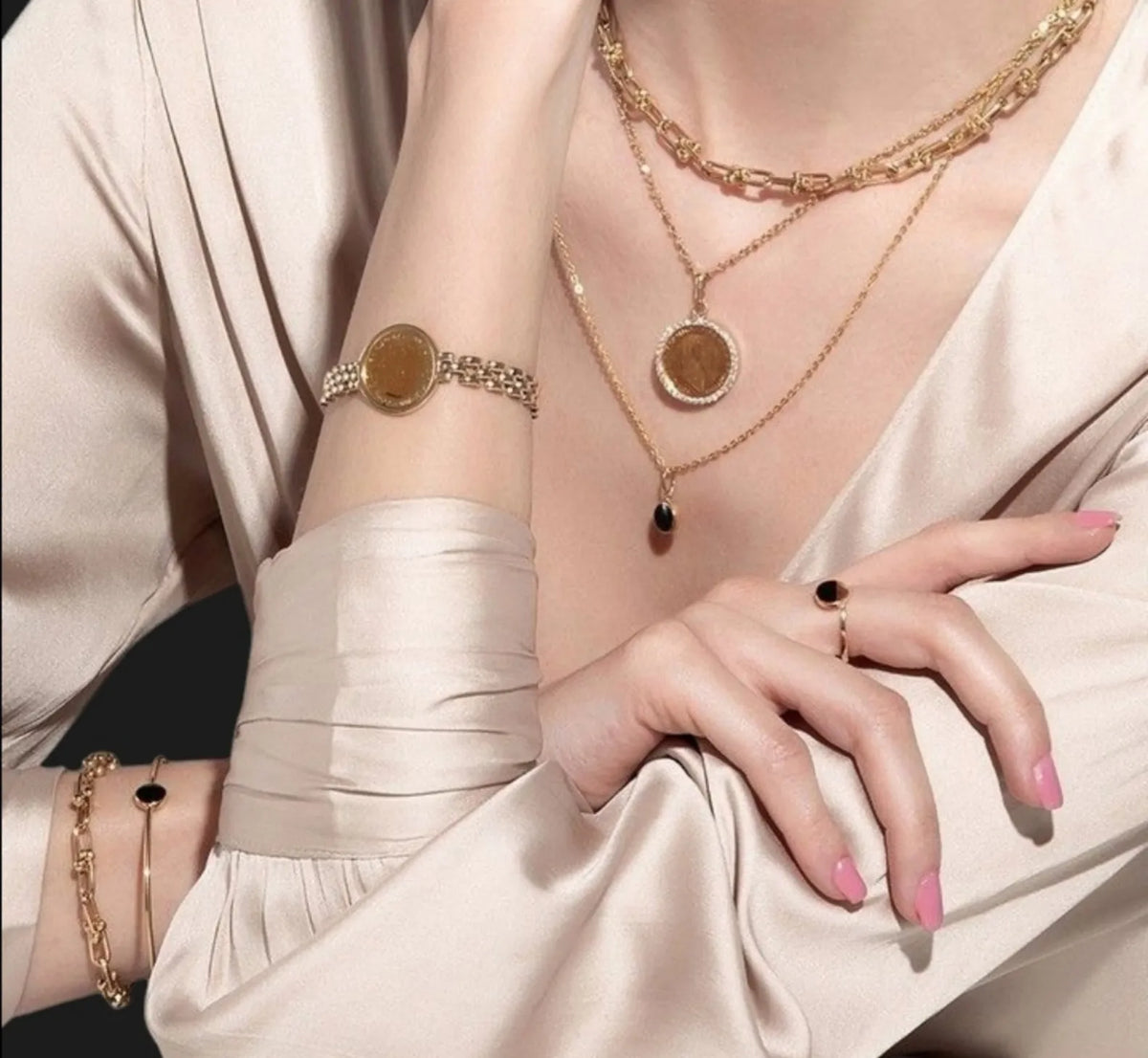 Model wearing gold coin necklaces and bracelet