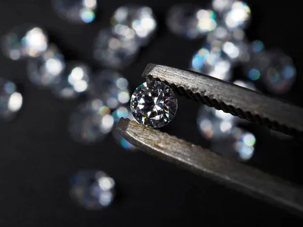 Loose diamond held in tweezers