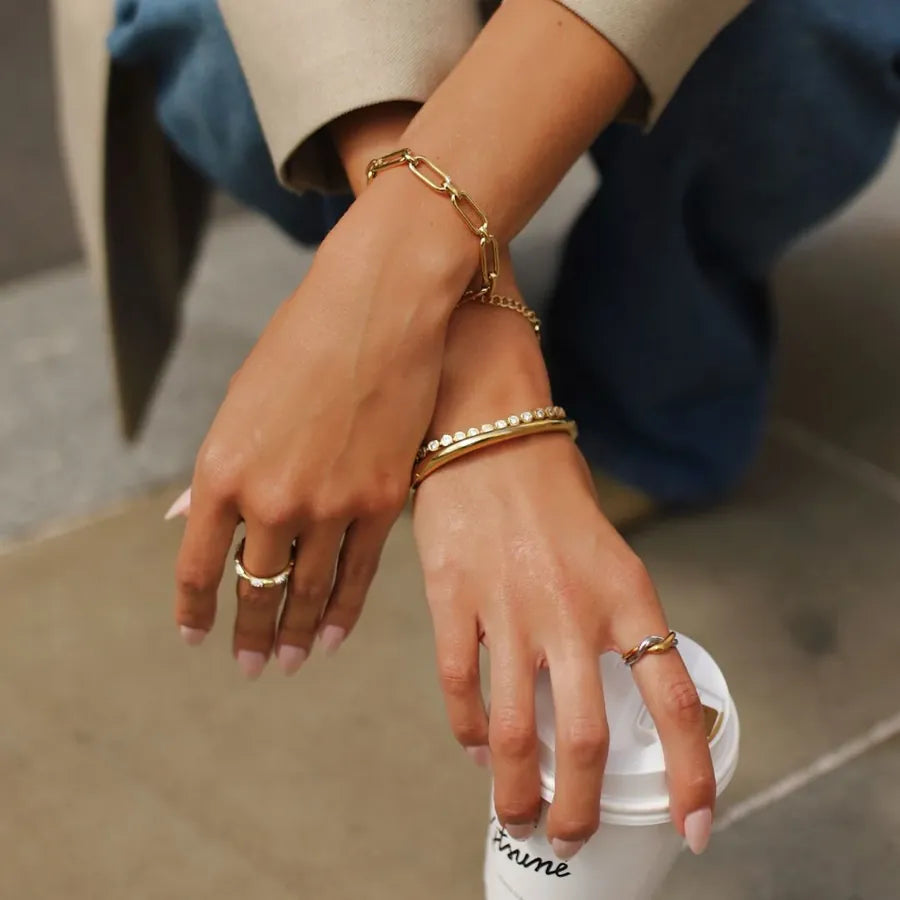 Gold bracelets and rings on wrists