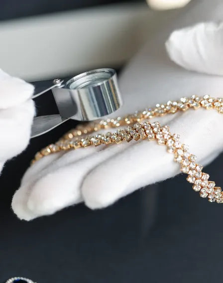 Jeweler inspecting a diamond bracelet with a loupe