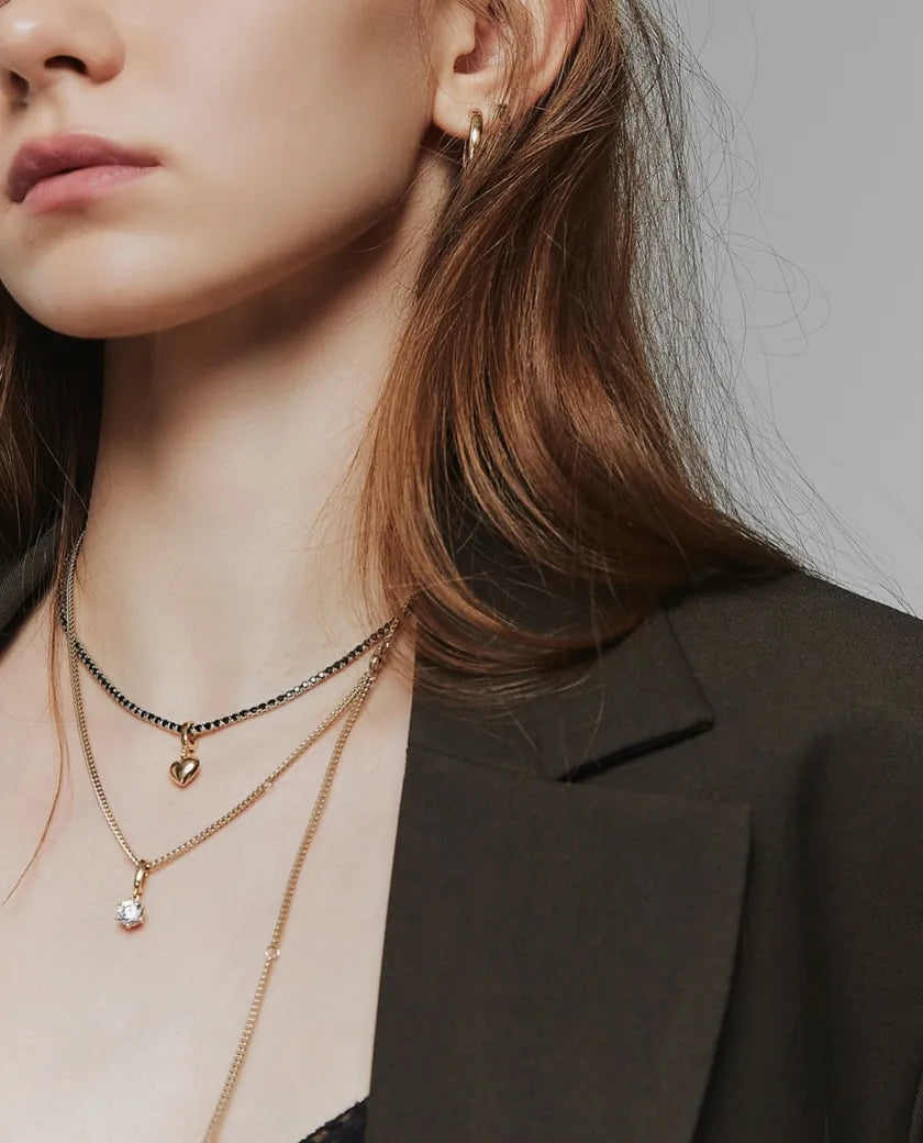 Model wearing delicate gold necklaces