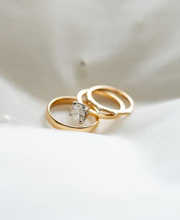 Gold wedding bands on white silk
