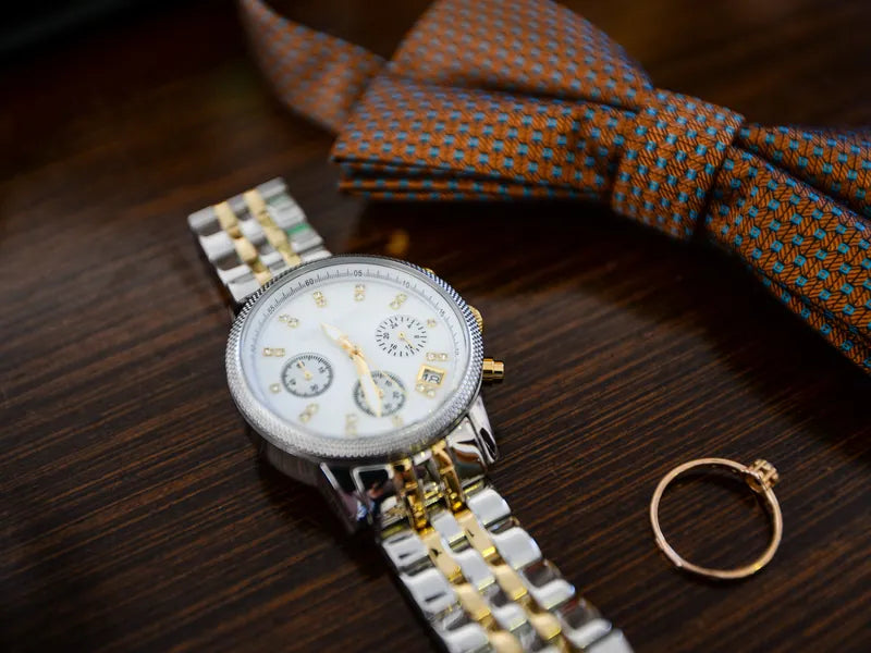 Watch and ring on a wooden table